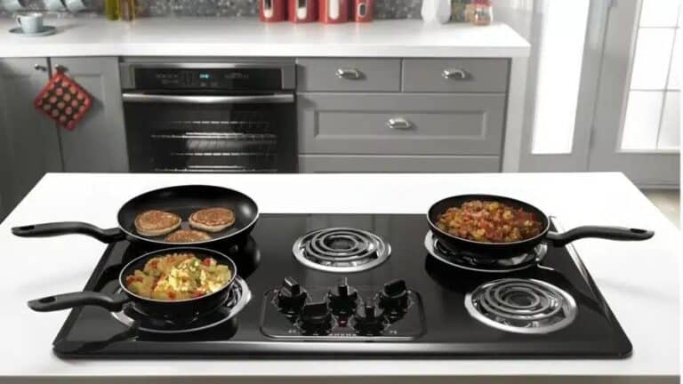 Cooktop preto com bocas elétricas em funcionamento, com panelas preparando diferentes pratos em uma cozinha moderna