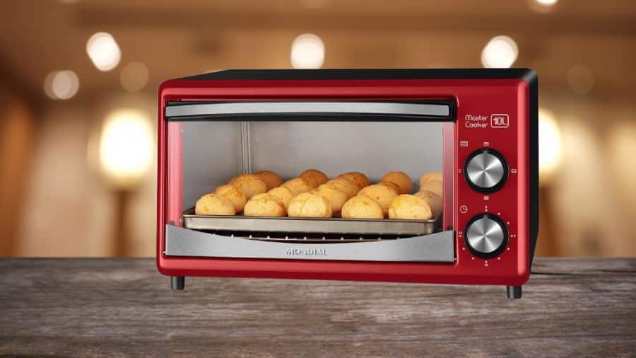 Forno elétrico de 10L vermelho da Mondial com pães de queijo assando, usado como imagem destacada do artigo