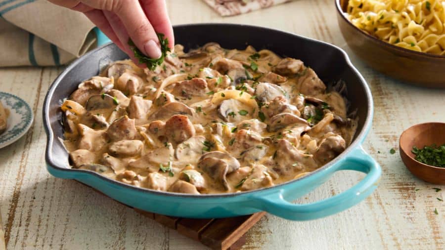Frigideira com strogonoff de frango cremoso, cogumelos frescos e cebola, finalizado com salsa picada