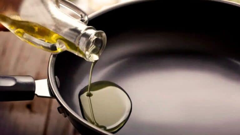 Óleo sendo despejado em frigideira antiaderente nova, usada como imagem destacada do artigo