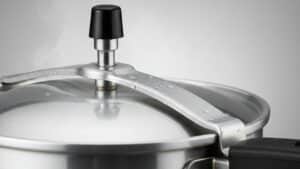 Panela de pressão com pino de segurança na tampa, mostrando o mecanismo responsável pelo controle da pressão, usada como imagem destacada do artigo