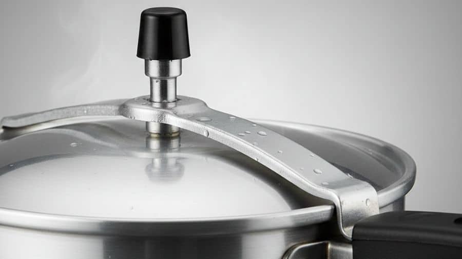 Panela de pressão com pino de segurança na tampa, mostrando o mecanismo responsável pelo controle da pressão, usada como imagem destacada do artigo