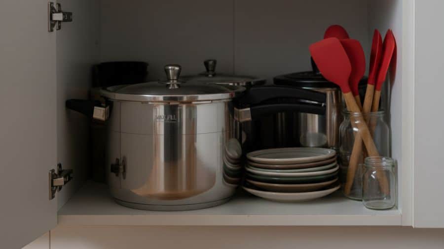 Panela de pressão grande ocupando espaço de armário pequeno em cozinha doméstica simples